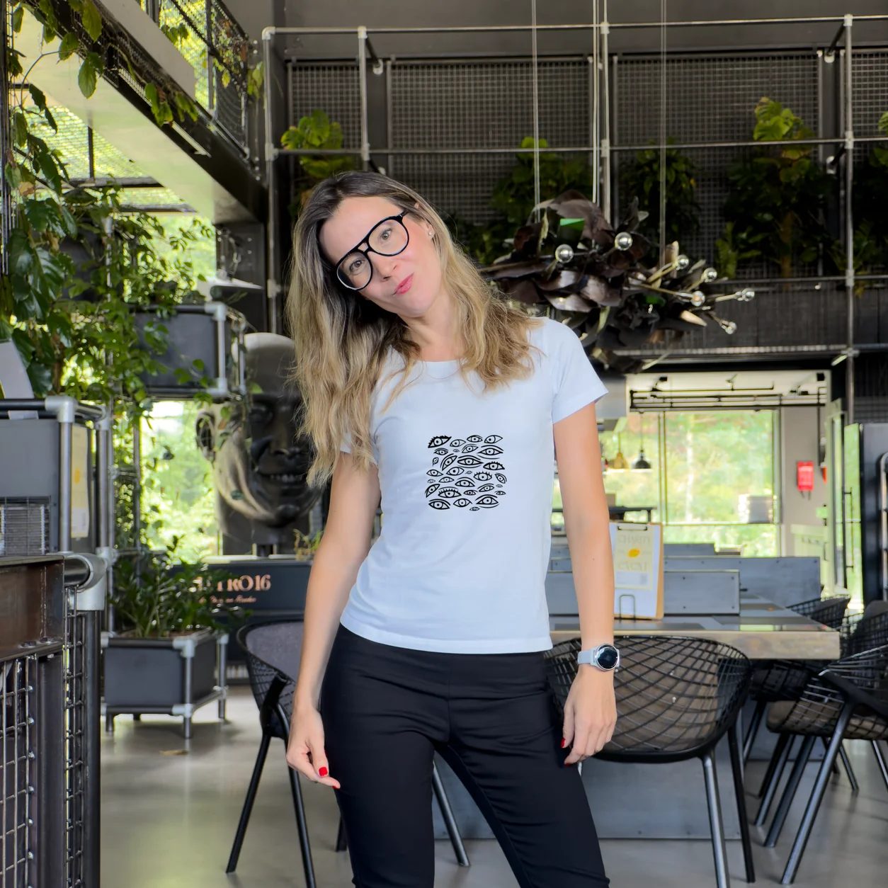 Accomplice standing in an industrial interior wearing an artist-designed white t-shirt