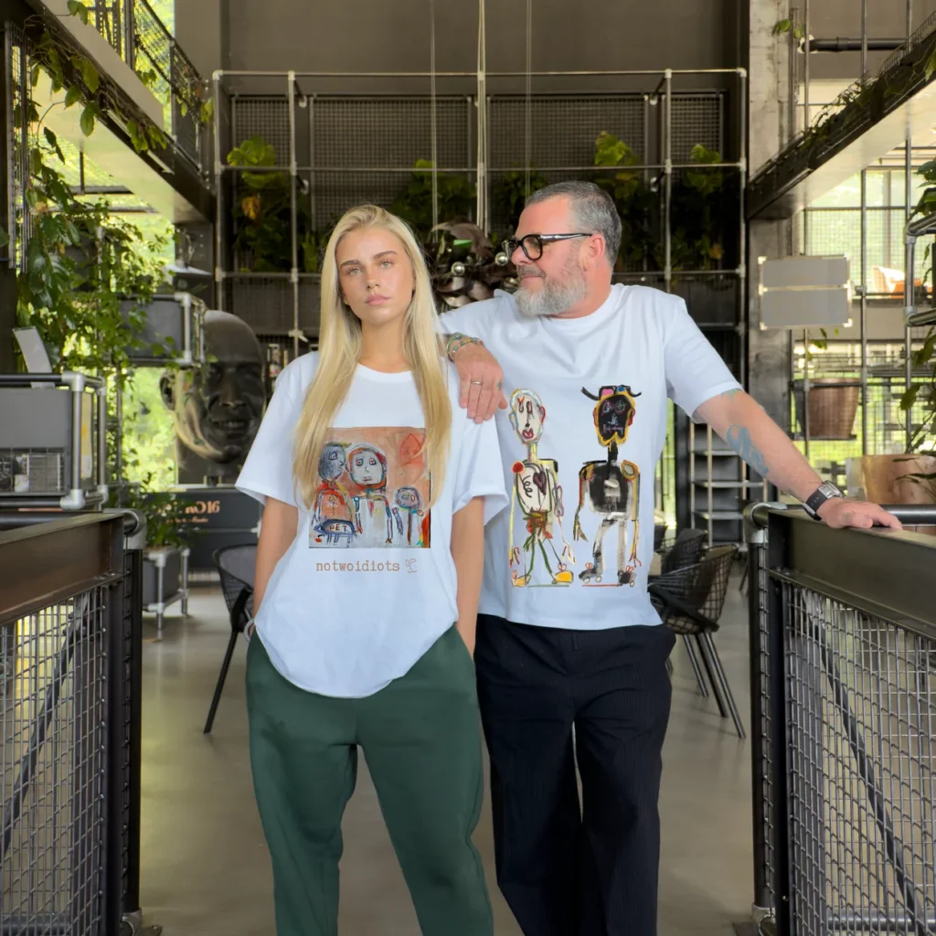 Accomplices wearing t-shirts with artist designs from The Invisible Plot — two accomplices side by side