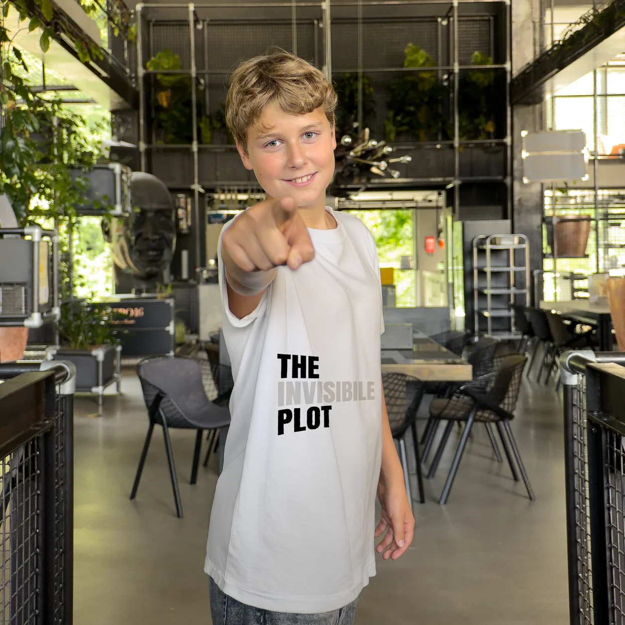 Accomplice wearing a t-shirt with The Invisible Plot logo — pointing at the camera