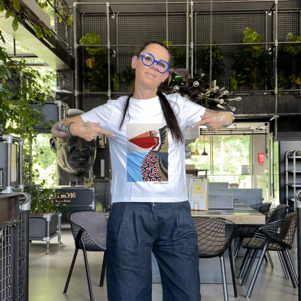 Accomplice pointing at the printed artwork on her white t-shirt