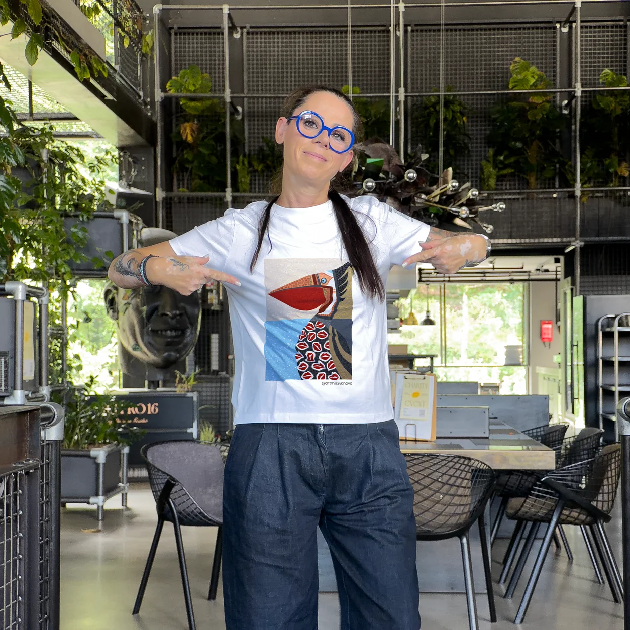 Accomplice pointing at the printed artwork on her white t-shirt