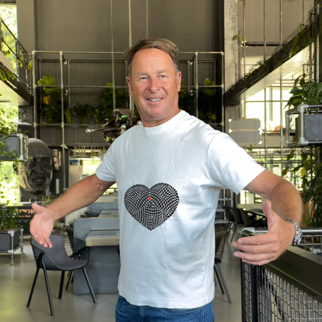 Accomplice stretching out his white t-shirt to show a black heart design