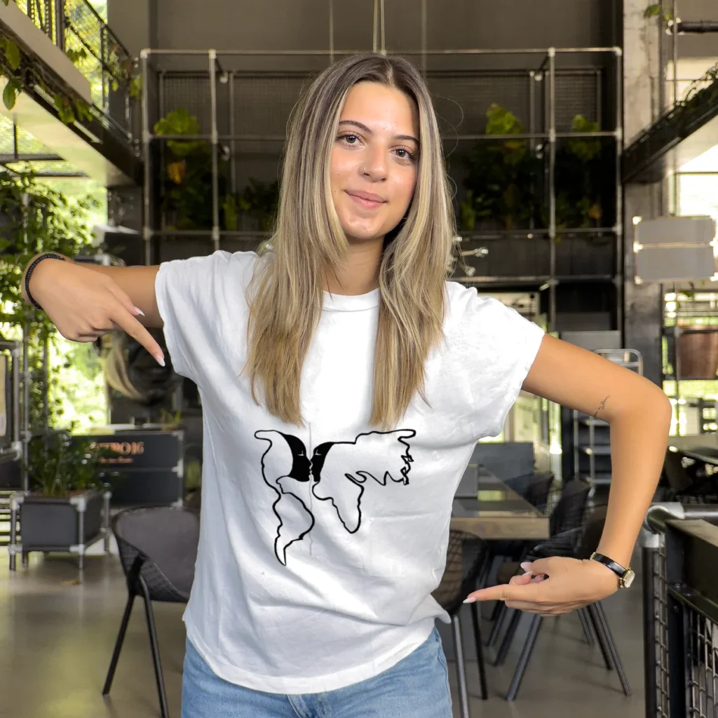 Accomplice pointing at the black line-drawing print on her white t-shirt