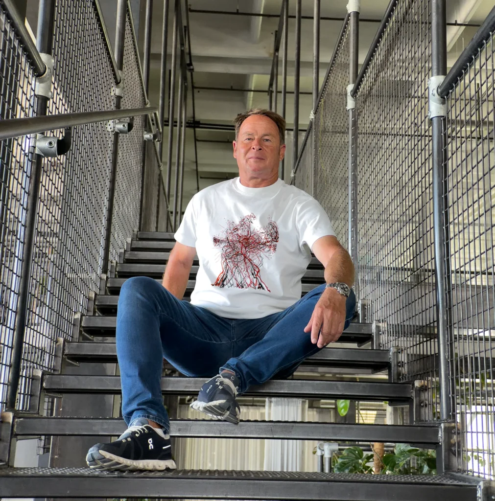 Accomplice wearing a t-shirt with an artist design from The Invisible Plot — red figure print