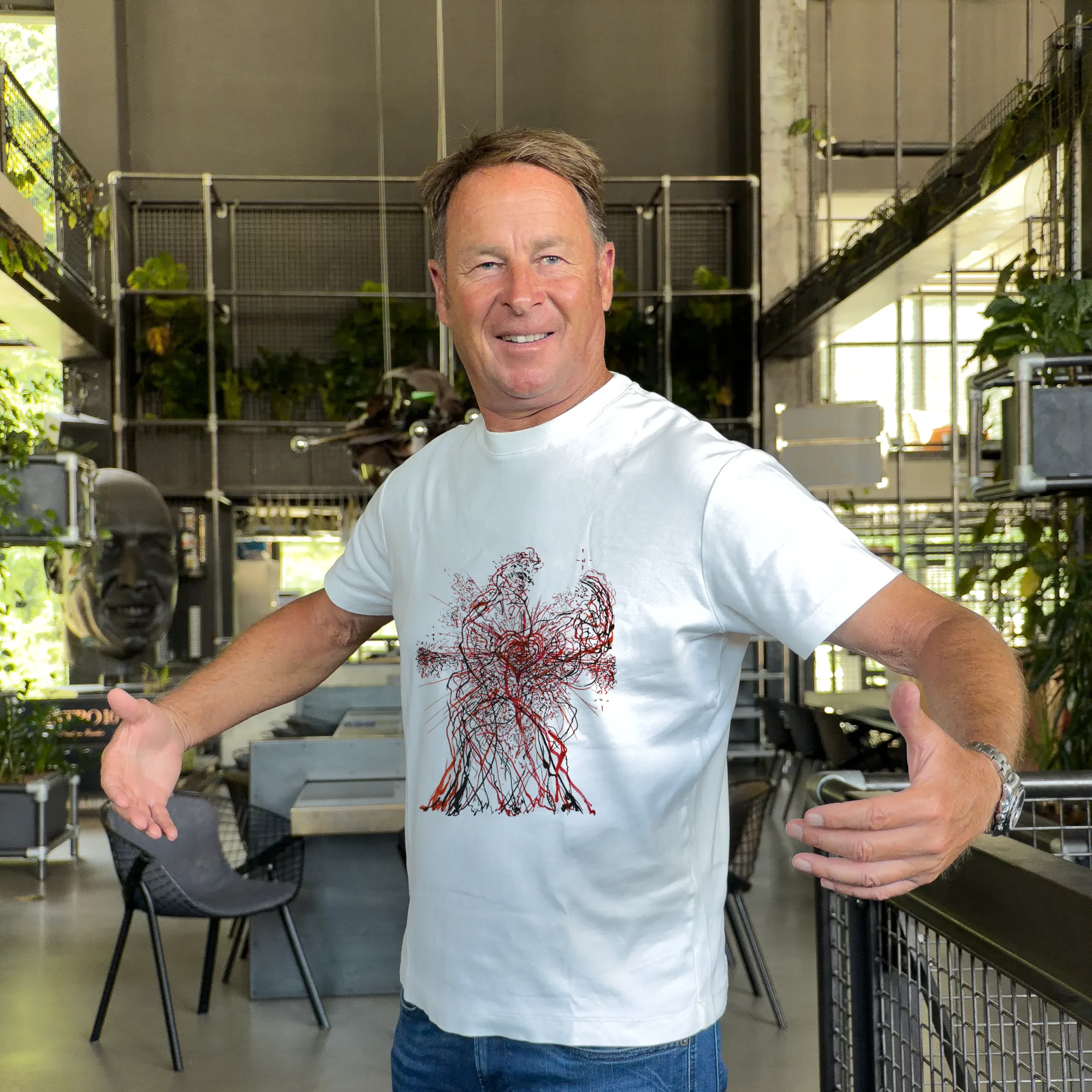 Accomplice wearing a t-shirt with an artist design from The Invisible Plot — red figure print, industrial interior